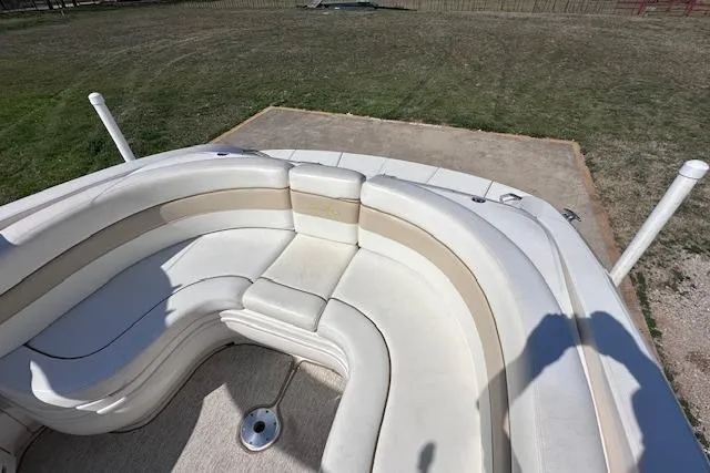 Slide: The Image of 2001 Sea Ray 290 Bowrider boat with spacious seating area, parked on grass. - 13