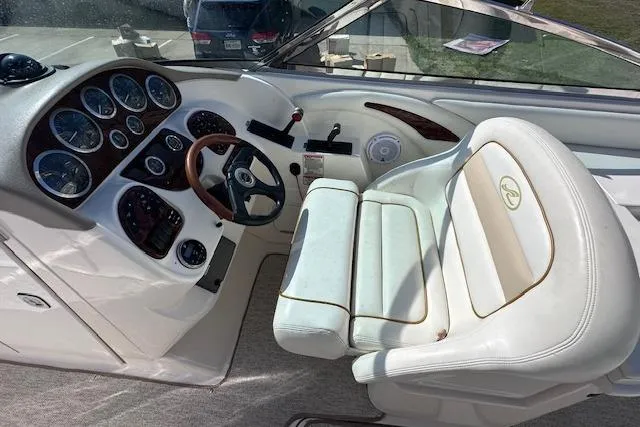 Slide: The Image of 2001 Sea Ray 290 Bowrider cockpit with white leather seating and instrument panel. - 14