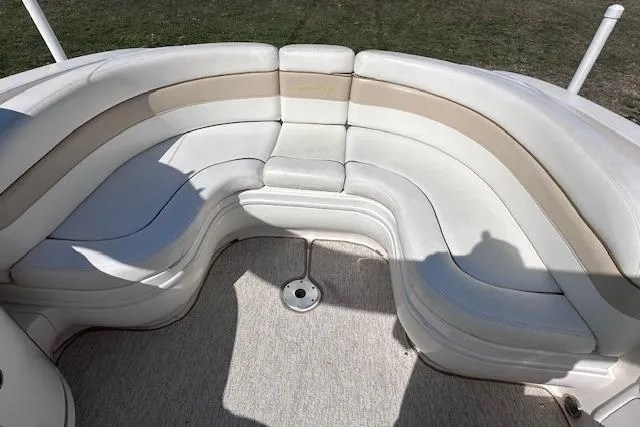 Slide: The Image of 2001 Sea Ray 290 Bowrider interior with curved white seating and beige accents. - 19
