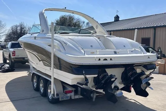 Slide: The Image of 2001 Sea Ray 290 Bowrider on trailer, parked outdoors near a building. - 2