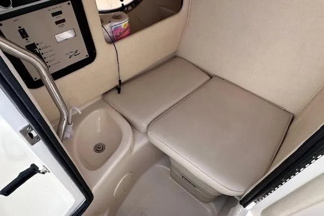 Slide: The Image of 2001 Sea Ray 290 Bowrider interior with cushioned seating and control panel. - 23
