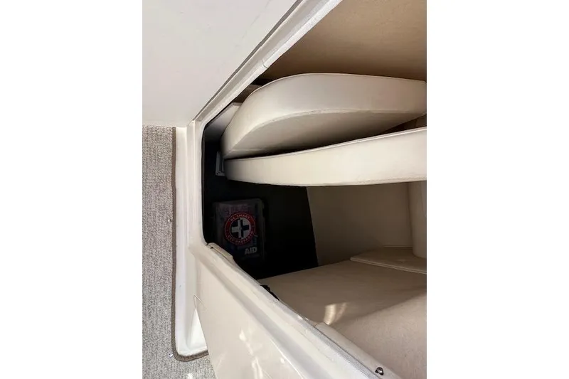 Slide: The Image of Interior storage compartment of 2001 Sea Ray 290 Bowrider with first aid kit. - 25