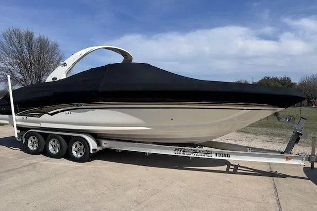 Slide: The Image of 2001 Sea Ray 290 Bowrider on trailer, covered, parked outdoors under blue sky. - 35