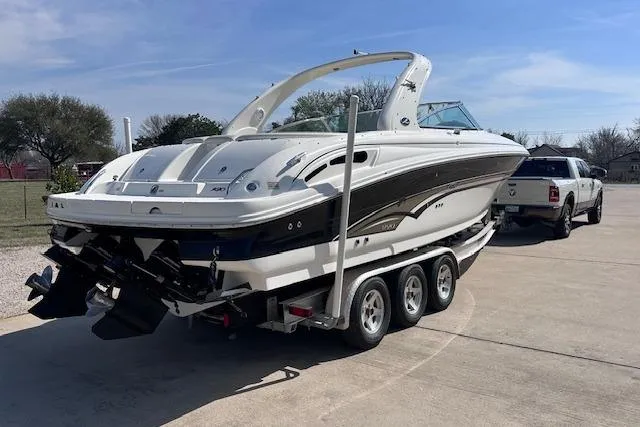 Slide: The Image of 2001 Sea Ray 290 Bowrider on trailer, parked outdoors, clear sky background. - 4