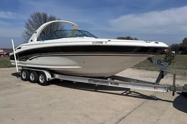 Slide: The Image of 2001 Sea Ray 290 Bowrider on a trailer, parked outdoors under a clear sky. - 5