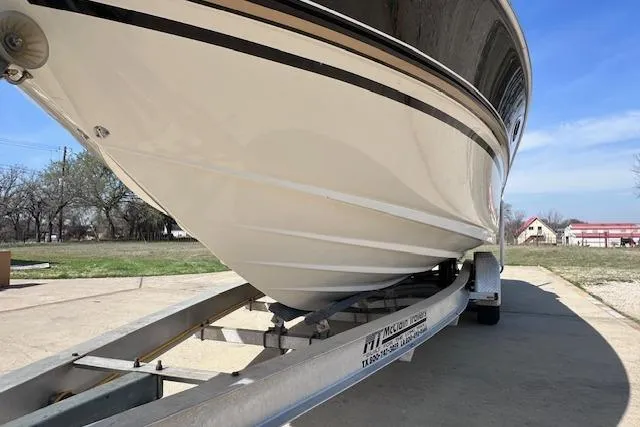 Slide: The Image of 2001 Sea Ray 290 Bowrider on trailer, parked outdoors under clear blue sky. - 7