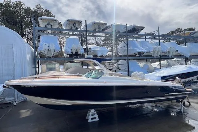 The Image of 2017 Chris-Craft Corsair 32 boat in storage, surrounded by other covered boats. - 0