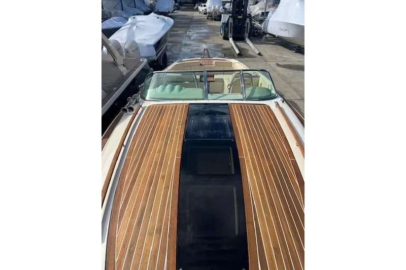 Slide: The Image of 2017 Chris-Craft Corsair 32 with sleek wooden deck, docked among other boats. - 19