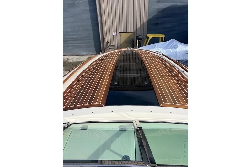 Slide: The Image of 2017 Chris-Craft Corsair 32 with sleek wooden deck design in a marina setting. - 21