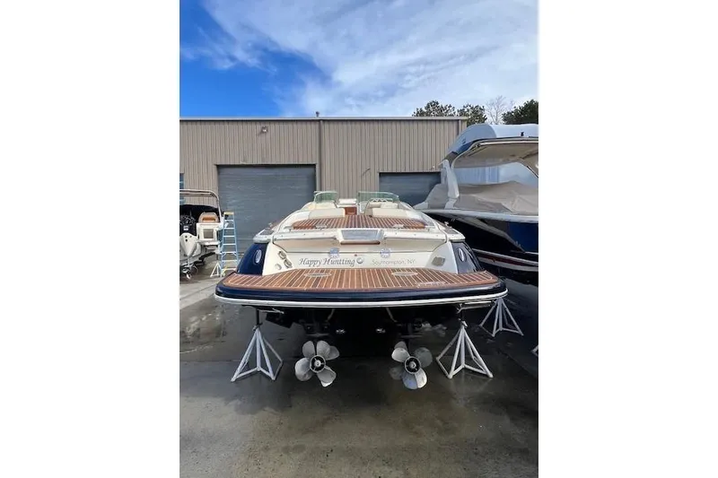 Slide: The Image of 2017 Chris-Craft Corsair 32 boat in storage, showcasing dual propellers and wooden deck. - 5