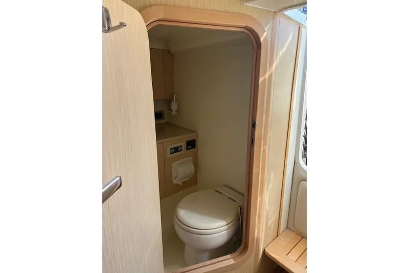 Slide: The Image of 2017 Chris-Craft Corsair 32 boat interior bathroom with wooden finish and compact design. - 9