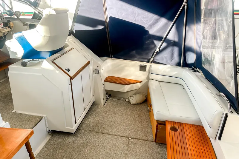 Slide: The Image of 1990 Carver 32 Montego boat interior with seating, helm, and wooden accents. - 17