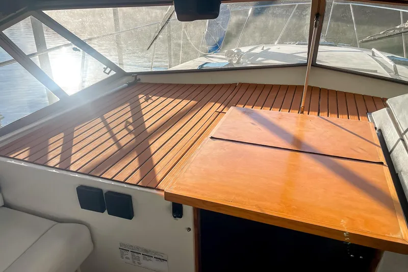 Slide: The Image of 1990 Carver 32 Montego boat interior with wooden deck and sunlight reflections. - 21
