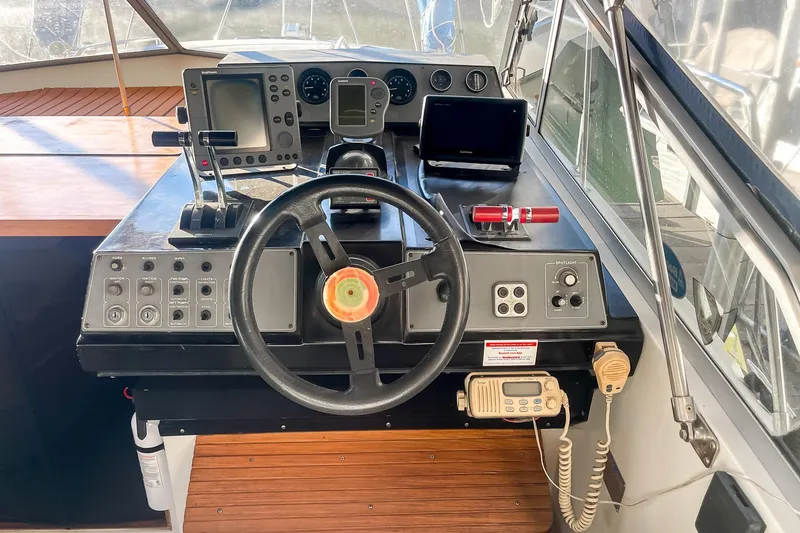 Slide: The Image of 1990 Carver 32 Montego helm with steering wheel, navigation equipment, and control panel. - 25