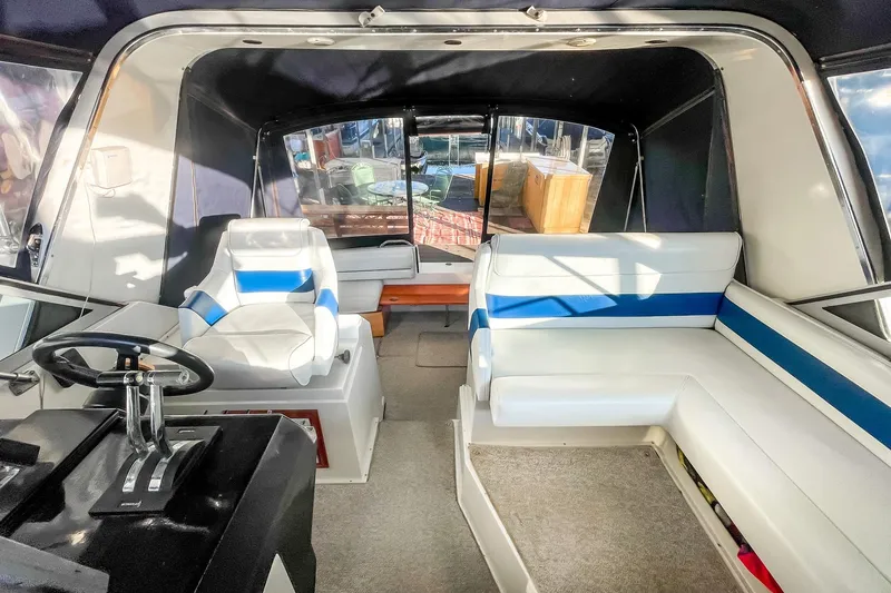 Slide: The Image of Interior of a 1990 Carver 32 Montego boat with white and blue seating. - 26