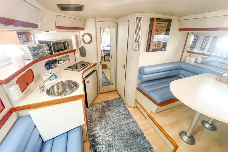 Slide: The Image of Interior of a 1990 Carver 32 Montego boat with kitchen and seating area. - 29