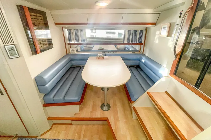 Slide: The Image of 1990 Carver 32 Montego interior with blue seating and wooden accents. - 35