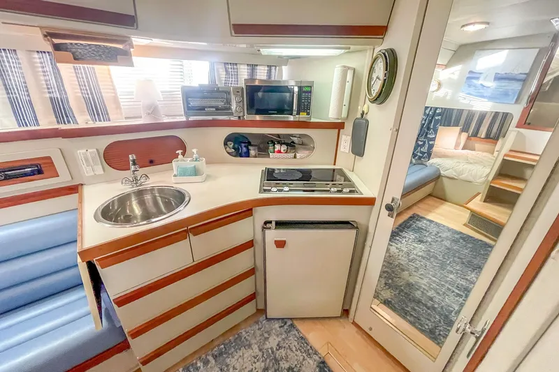 Slide: The Image of Interior of a 1990 Carver 32 Montego yacht with kitchenette and seating area. - 36