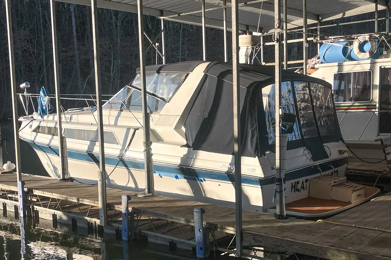 Slide: The Image of 1990 Carver 32 Montego boat docked under a covered marina. - 7