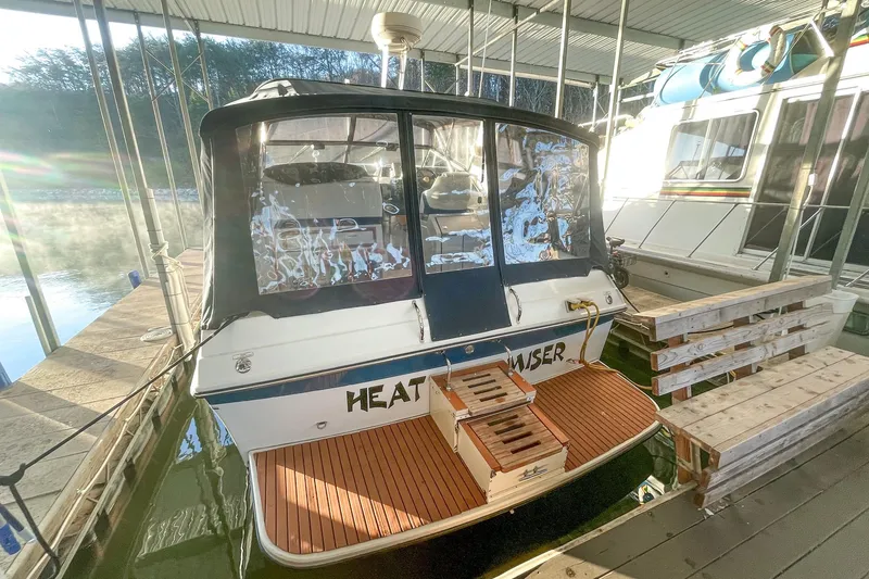Slide: The Image of 1990 Carver 32 Montego boat docked in a marina with wooden deck. - 8
