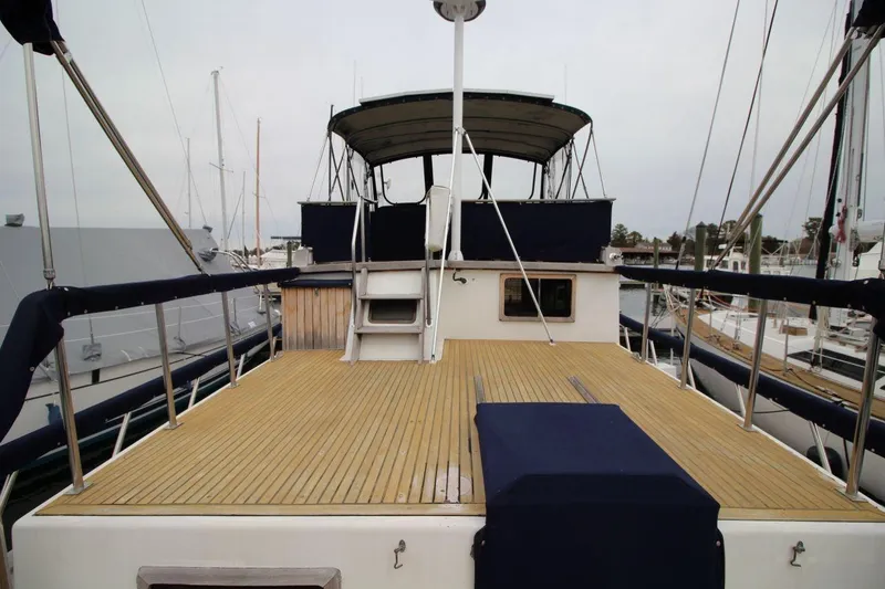 Slide: The Image of 1986 DeFever 41 Trawler with spacious deck and covered helm station in marina. - 10