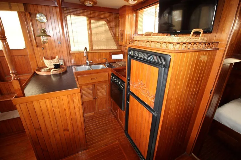 Slide: The Image of 1986 DeFever 41 Trawler interior with wood paneling, kitchen, and appliances. - 22