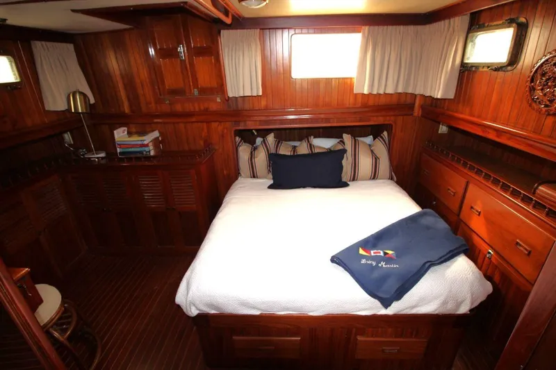 Slide: The Image of 1986 DeFever 41 Trawler cabin with wooden interior, cozy bed, and nautical decor. - 23