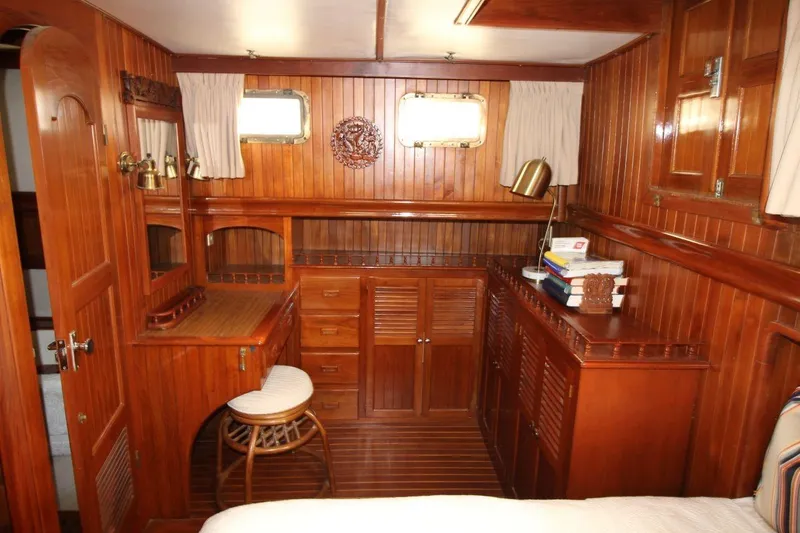 Slide: The Image of 1986 DeFever 41 Trawler interior with wooden cabinetry and nautical decor. - 25