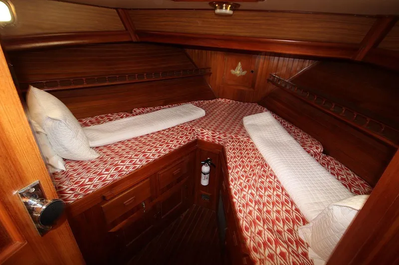 Slide: The Image of 1986 DeFever 41 Trawler cabin with red patterned bedding and wooden interior. - 27