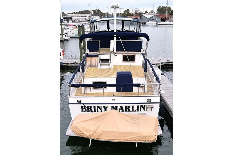 Slide: The Image of 1986 DeFever 41 Trawler docked, rear view with covered dinghy. - 3