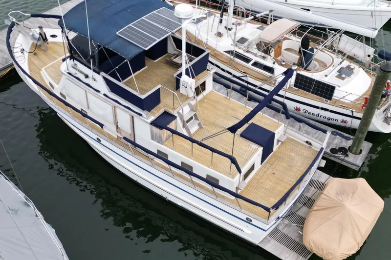 Slide: The Image of 1986 DeFever 41 Trawler docked, featuring solar panels and spacious deck. - 7