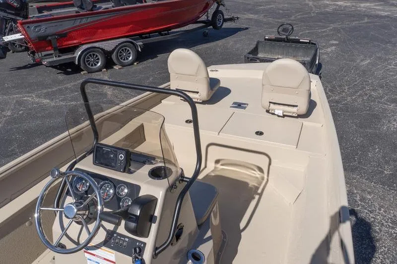 Slide: The Image of 2026 G3 Bay 20 boat interior with steering console and seating, parked on asphalt. - 11