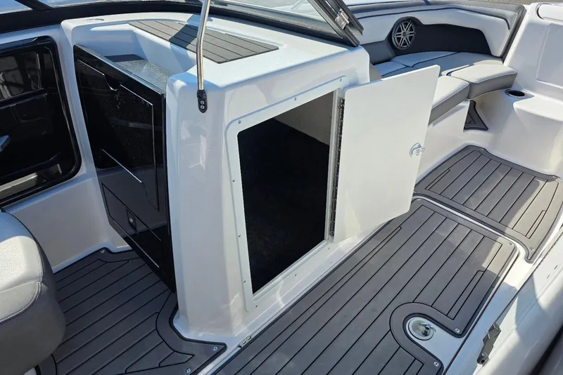 Slide: The Image of 2017 Yamaha Boats 212 Limited interior with open storage compartment and seating area. - 17