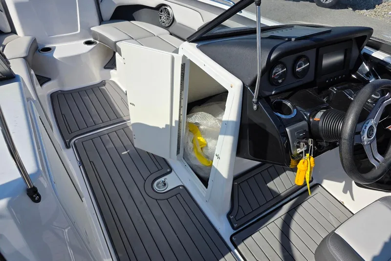 Slide: The Image of 2017 Yamaha Boats 212 Limited interior with open storage, steering wheel, and seating area. - 18