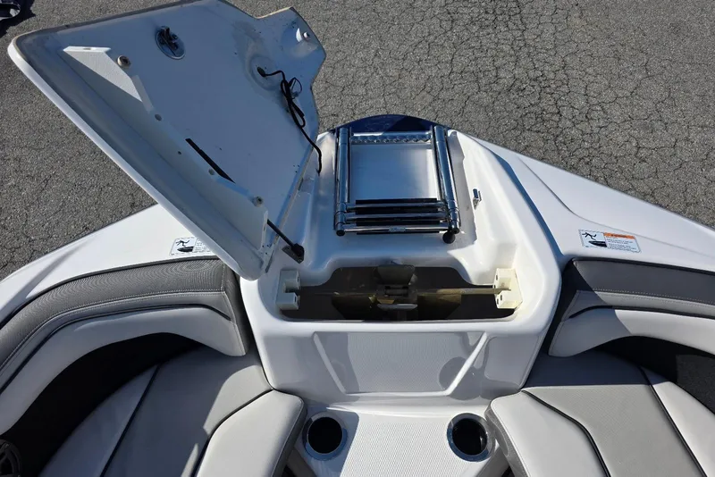 Slide: The Image of 2017 Yamaha Boats 212 Limited bow storage compartment with open hatch and seating. - 22