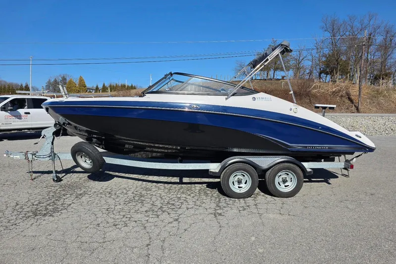 The Image of 2017 Yamaha Boats 212 Limited on trailer, parked outdoors under clear blue sky. - 4