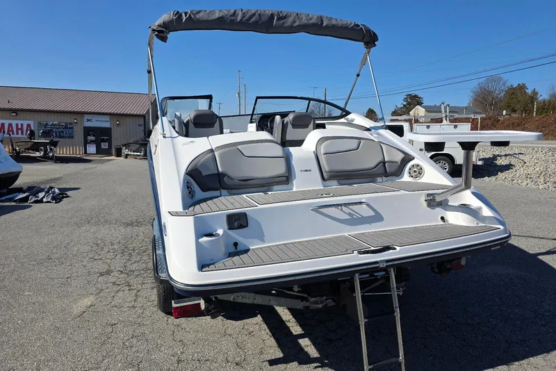 Slide: The Image of 2017 Yamaha Boats 212 Limited, rear view, parked outdoors on a sunny day. - 9