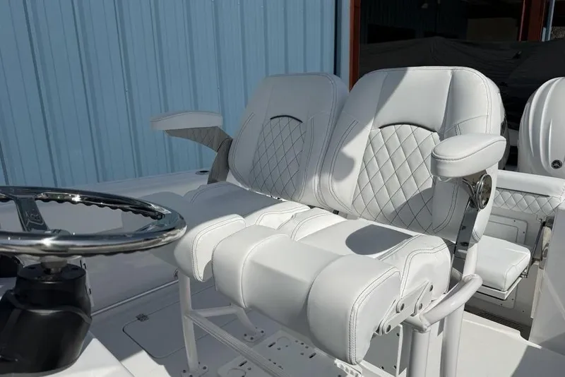 Slide: The Image of 2026 Sportsman Open 252 Center Console boat with luxurious white seating and steering wheel. - 14