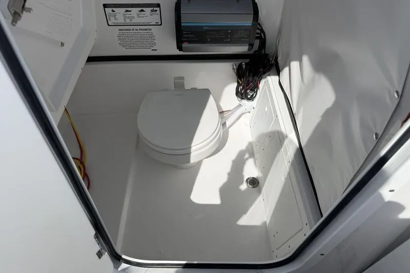 Slide: The Image of 2026 Sportsman Open 252 Center Console boat interior with compact marine toilet. - 23