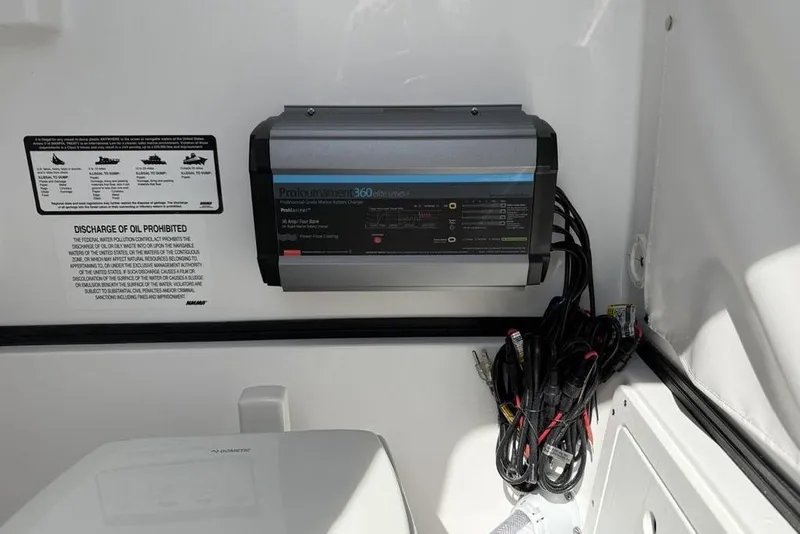Slide: The Image of Battery charger and cables inside 2026 Sportsman Open 252 Center Console boat. - 31