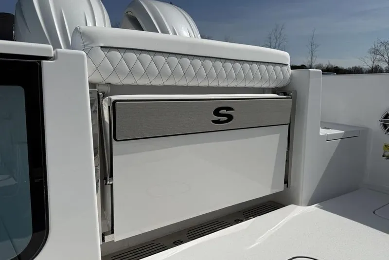 Slide: The Image of 2026 Sportsman Open 252 Center Console boat interior with quilted seating and storage compartment. - 35