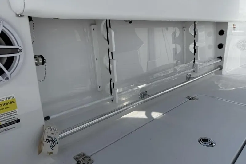 Slide: The Image of 2026 Sportsman Open 252 Center Console interior storage compartment with speaker and safety label. - 43