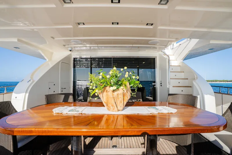 Slide: The Image of Luxurious yacht deck with elegant wooden table, floral centerpiece, and ocean view. Custom Line 100, 2012. - 11