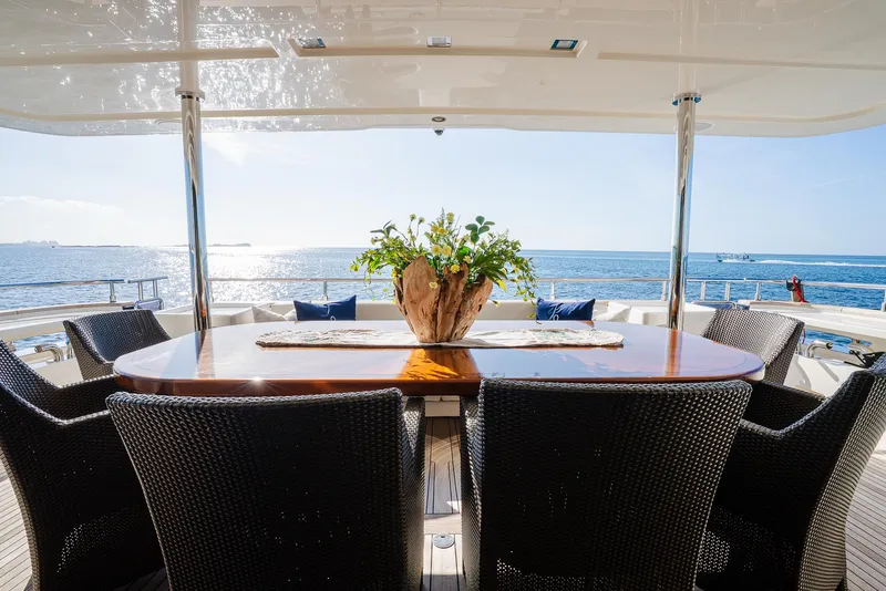 Slide: The Image of Luxurious yacht deck with elegant dining area, ocean view, and stylish wicker chairs. Custom Line 100, 2012. - 12
