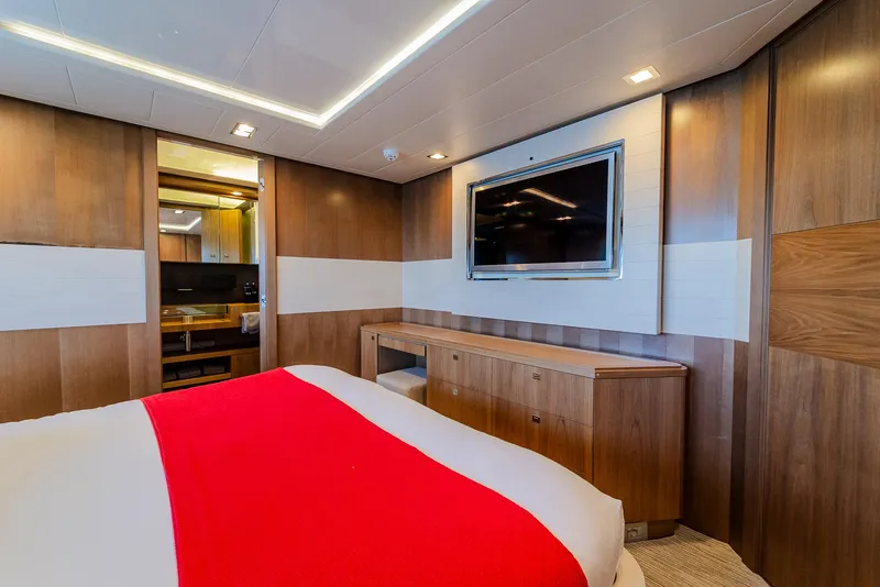 Slide: The Image of Luxurious yacht bedroom with wood paneling, red bedspread, and wall-mounted TV, Custom Line 100, 2012. - 25