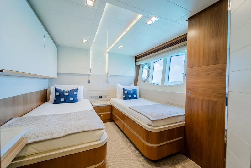 Slide: The Image of Luxurious twin cabin on 2012 Custom Line 100 yacht with modern decor and porthole windows. - 27
