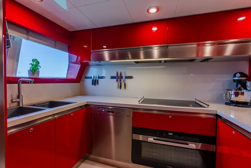Slide: The Image of Modern kitchen with red cabinets, stainless steel appliances, and a window view. Custom Line 100, 2012. - 34