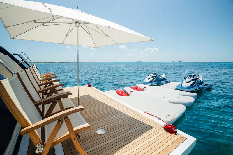 Slide: The Image of Luxury yacht deck with chairs, umbrella, and jet skis on a sunny day, Custom Line 100, 2012. - 9