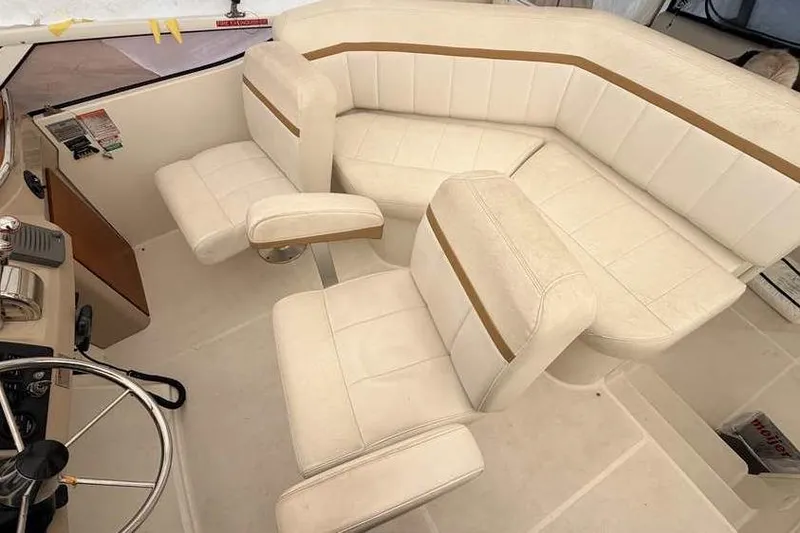 Slide: The Image of 2006 Carver 41 Cockpit Motor Yacht interior with white seating and control panel. - 16