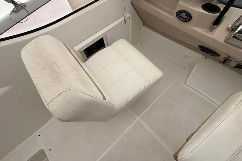Slide: The Image of 2006 Carver 41 Cockpit Motor Yacht helm with white seating and navigation controls. - 17